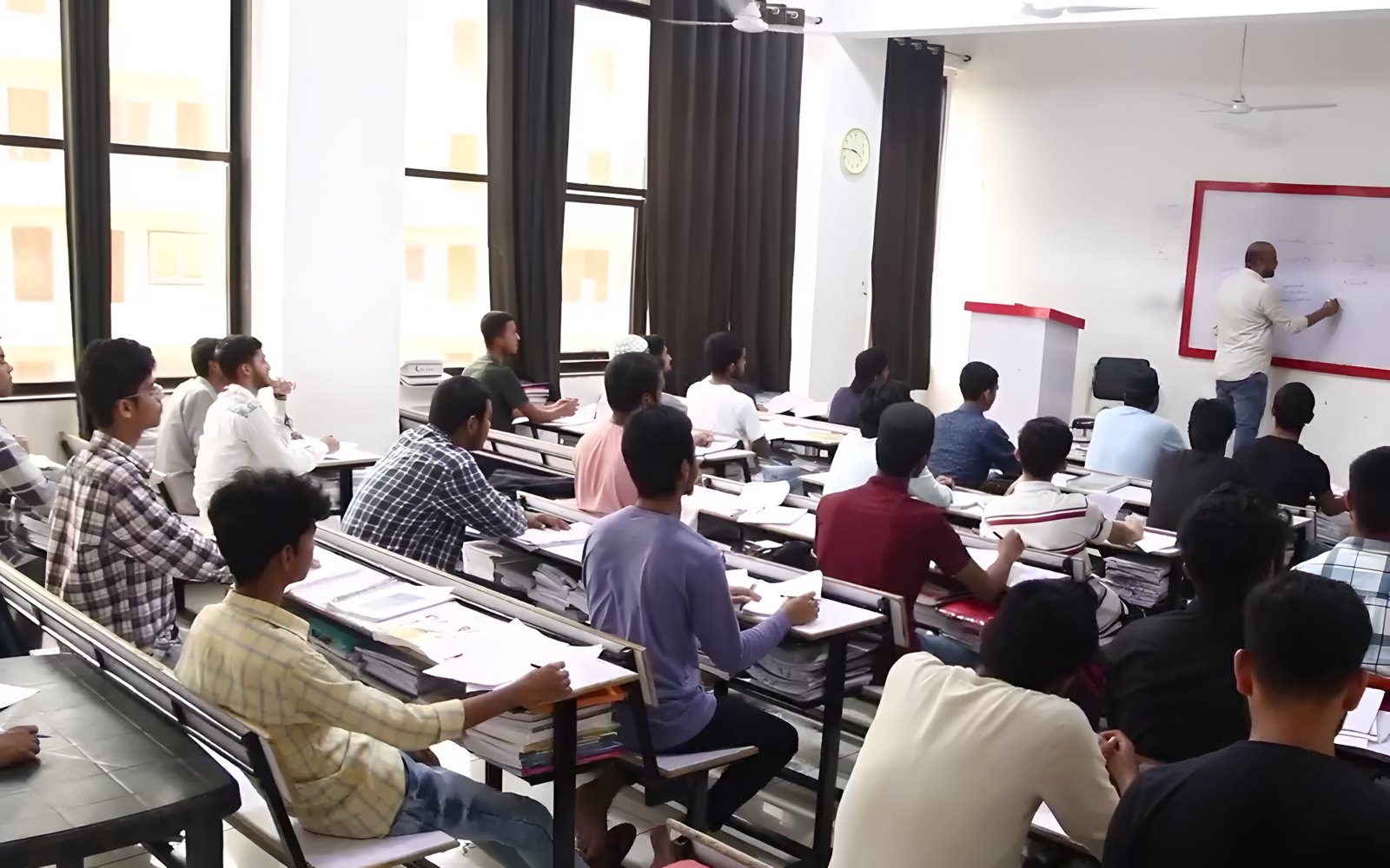 A teacher explaining a problem to students at the board